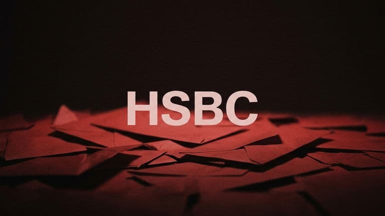 The word HSBC in large pale letters over a blurred heap of red paper envelopes against a dark background.
